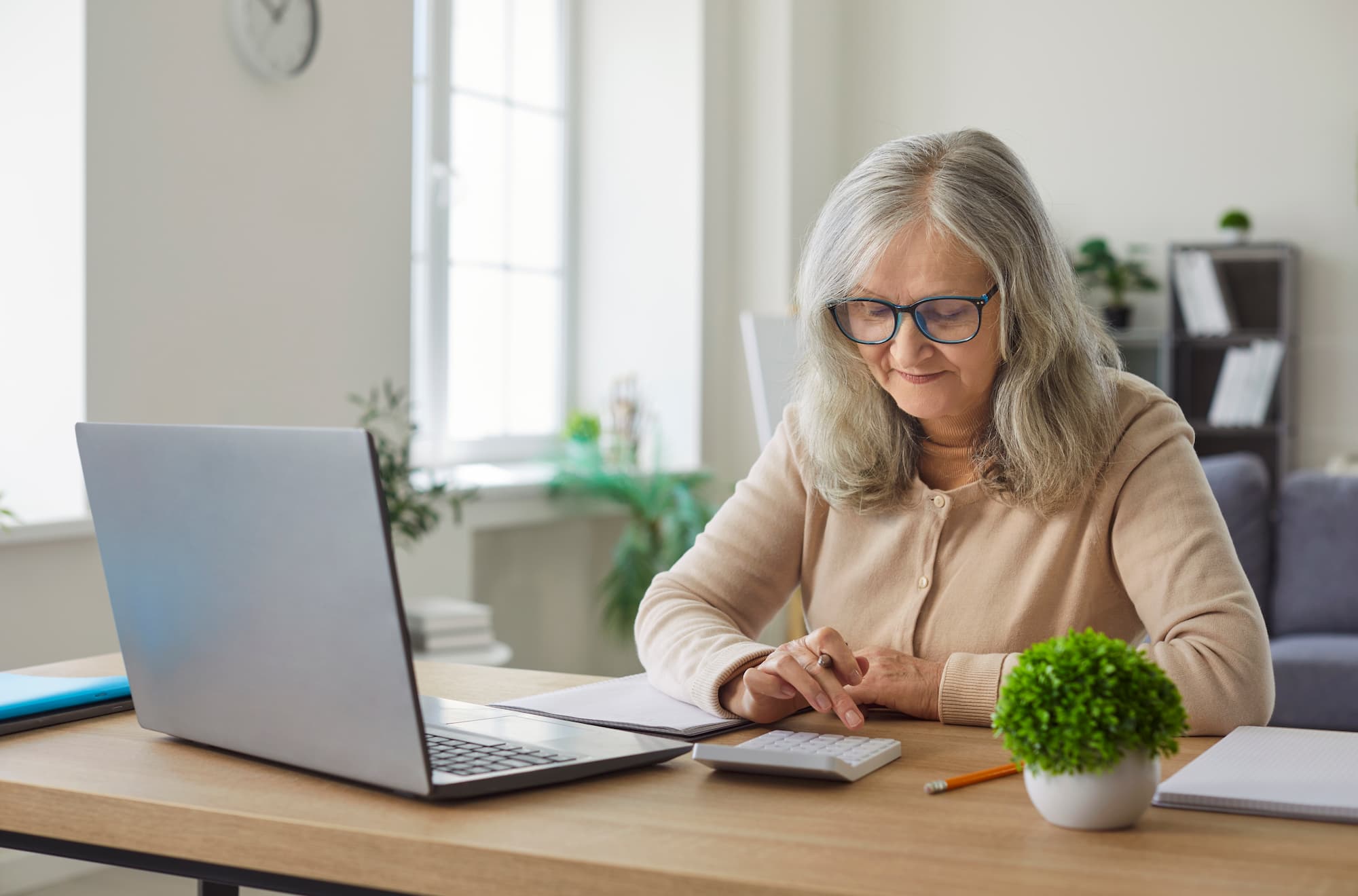 Older woman reviewing senior living costs in Bartlesville, Oklahoma, on a laptop